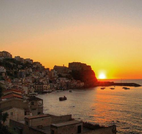 a sunset over a city with boats in the water at Romeo e Giulietta Scilla in Scilla