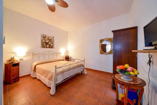 1 dormitorio con 1 cama y 1 mesa con TV en L'Antico Carrettiere, en Peschici