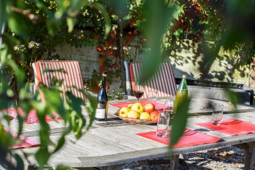 a picnic table with a basket of fruit and wine bottles at Arboris Appartement in Appiano sulla Strada del Vino