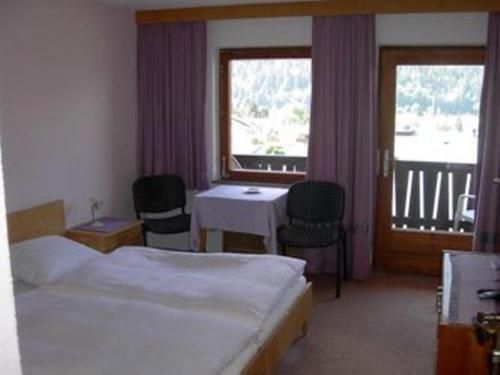 ein Hotelzimmer mit 2 Betten, einem Tisch und Stühlen in der Unterkunft Haus Michael in Oetz