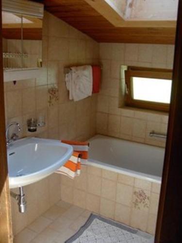 a bathroom with a white tub and a sink at Haus Michael in Oetz