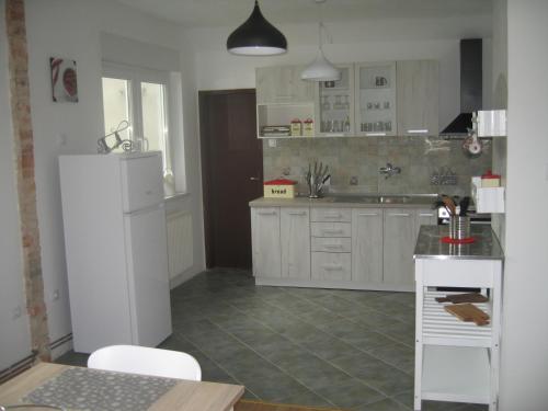 a kitchen with white cabinets and a white refrigerator at R&G APARTMENT in Žirovnica