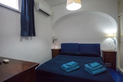 a bedroom with a blue bed with two towels on it at Casa del Mare in Capri