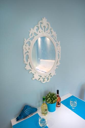 a table with a mirror and some bottles and glasses at Sunset Apartments Free shuttle from Athen's Airport in Spáta