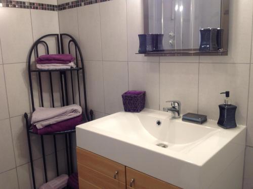 une salle de bain avec un lavabo, un miroir et des serviettes dans l'établissement le lutin sur le toit, à Mazan