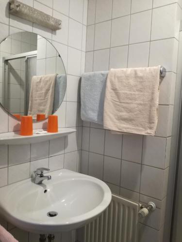 a bathroom with a sink and a mirror and towels at Zeesener Gasthof in Königs Wusterhausen