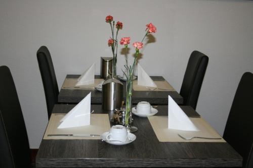a wooden table with flowers on top of it at Hotel am Bad in Esslingen
