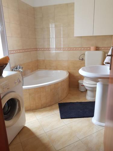 a bathroom with a tub and a toilet and a sink at Apartman Vesna in Peroj