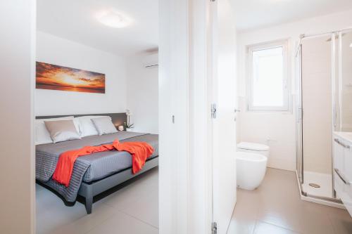 リニャーノ・サッビアドーロにあるVilla Annaのベッドルーム1室(オレンジの毛布付きのベッド1台付)