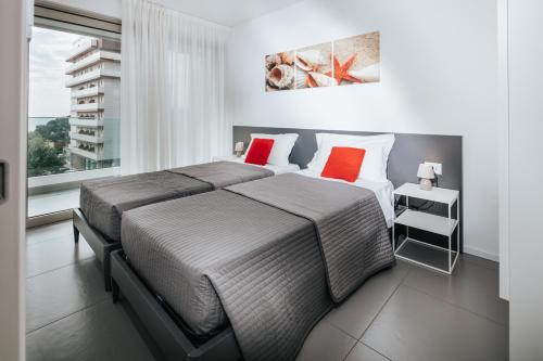 リニャーノ・サッビアドーロにあるVilla Annaのベッドルーム1室(大型ベッド1台、赤い枕2つ付)