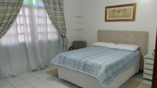a bedroom with a bed and a window at London House in São José
