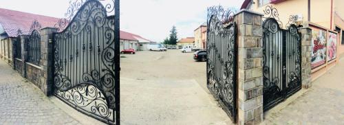 an iron gate on a street next to a building at Bolero plus in Mukacheve
