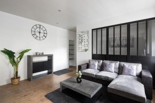a living room with a couch and a fireplace at Zen et design, proche Cité Corsaire in Saint Malo