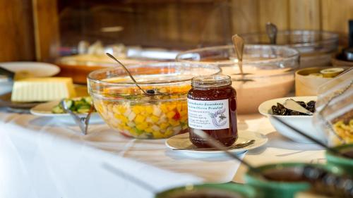 a table with a jar of honey and a bowl of food at Sattleggers Alpenhof & Feriensternwarte in Berg im Drautal