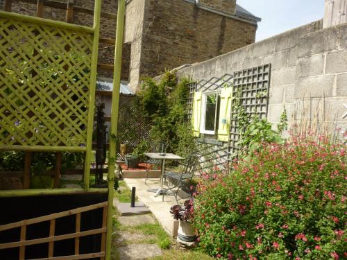 a garden with a table and some flowers and a building at Gîte "L'Escale Marine" in Cancale