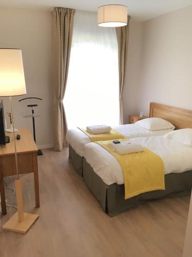a hotel room with two beds and a window at Domitys Rosa Gallica in Angers