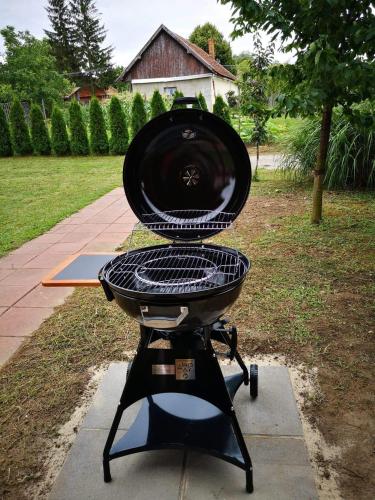 a grill sitting on a stand in a yard at Apartmany-Anna in Podhájska