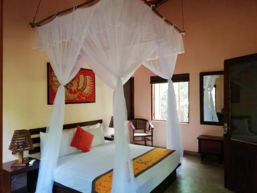 a bedroom with a bed with a canopy at Kuwera Eco Lodge in Sigiriya