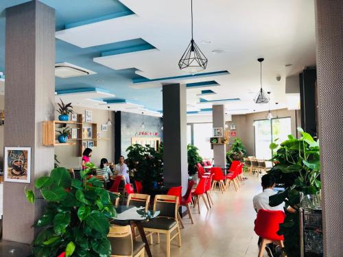 a restaurant with blue ceilings and tables and chairs at Hồng Hạc Hotel in Tuy Hoa