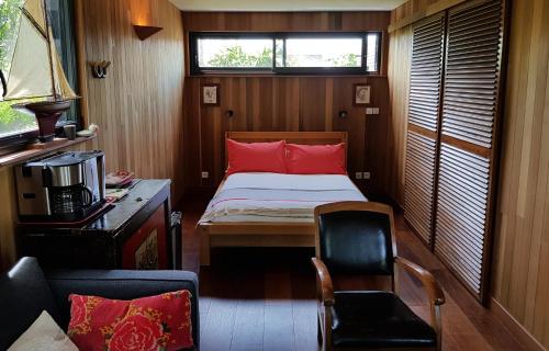 1 dormitorio pequeño con 1 cama y 1 silla en Ty Polder, en Île-Tudy