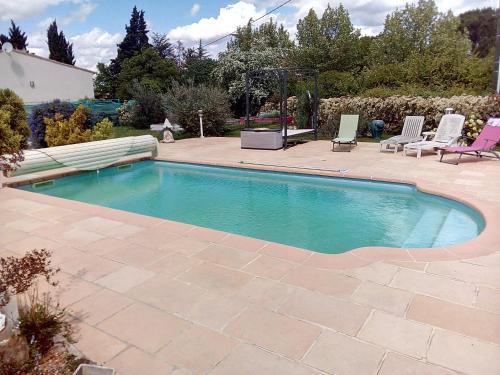 einen Pool in einem Garten mit Stühlen und einer Terrasse in der Unterkunft Casa Lucia in Saint-Maximin-la-Sainte-Baume