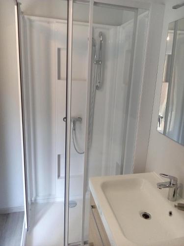 une salle de bain blanche avec une douche et un lavabo dans l'établissement Casa Lucia, à Saint-Maximin-la-Sainte-Baume