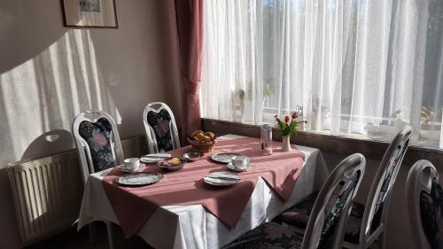 a dining room table with a pink table cloth at Pension Waldfrieden in Wolkenstein