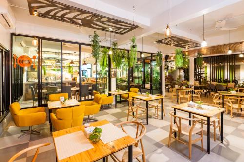 a restaurant with wooden tables and yellow chairs at Simple Life Cliff View Resort in Koh Tao
