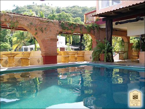 una piscina frente a una casa en Hotel La Cabaña, en Puerto Ángel