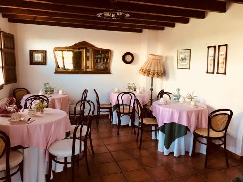 una stanza con tavoli e sedie con tovaglie rosa di Posada Fuentedevilla a Pechón