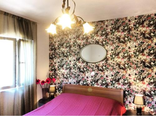 a bedroom with a pink bed with a flower wall at Faros oasis in Gdinj