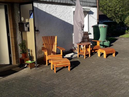 a group of wooden chairs sitting next to a building at Ferienhaus Broche in Hilchenbach