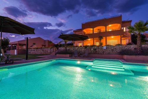 a swimming pool in front of a house at Apartment Alex in Zadar