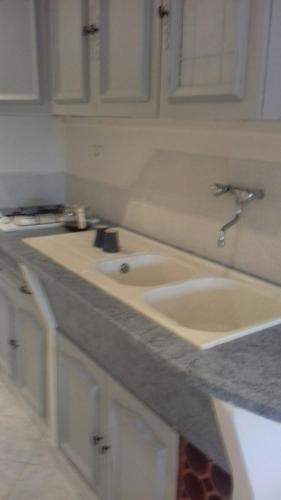 un comptoir de cuisine avec deux lavabos et des armoires blanches dans l'établissement palayson two, au Muy