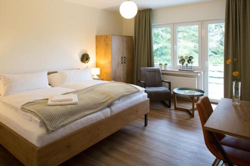 a bedroom with a bed and a desk and a window at Ferienwohnung im Hasetal in Löningen