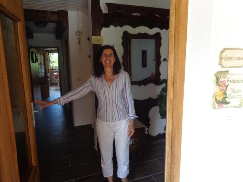 a woman standing in a hallway with her arm out at Gästehaus Eschenhof in Reit im Winkl