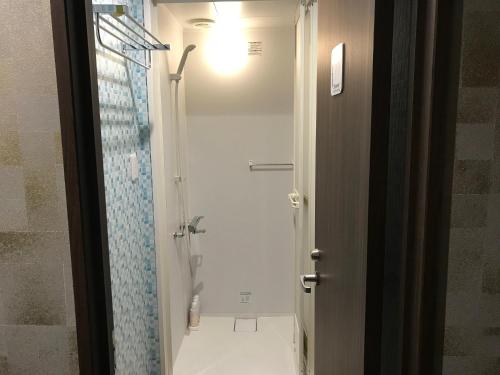 a bathroom with a shower with a glass door at Hotel Famitic Nikko Station in Nikko