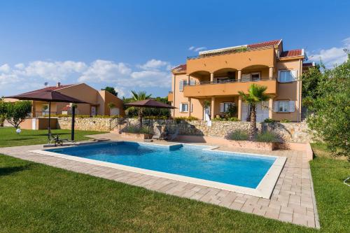 a villa with a swimming pool in front of a house at Apartment Alex in Zadar