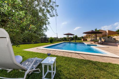 a swimming pool in a yard with a chair and a table at Apartment Alex in Zadar
