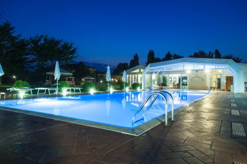 una piscina notturna con un edificio illuminato di Agriturismo Lama Di Valle Rosa a Ferrara