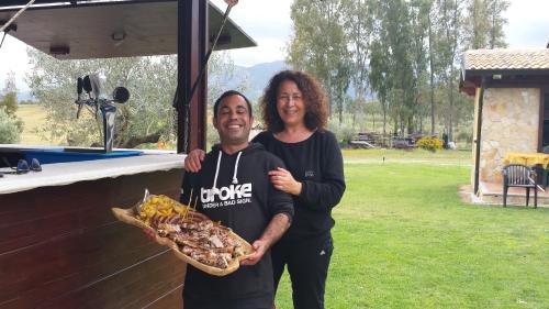 a man and a woman holding a tray of food at Agriturismo Monte Majore in Siliqua