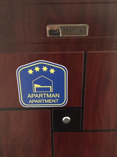 a sign for an apartment apartment on a wooden drawer at Apartman Ljutovac in Gornja Toplica