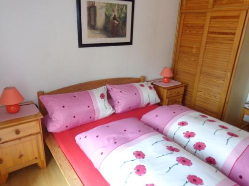 a bedroom with two beds with pink and white pillows at Gästehaus Eschenhof in Reit im Winkl