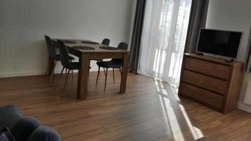 シュツァブニツァにあるApartament "Marzenie cepra"のダイニングルーム(テーブル、椅子、テレビ付)