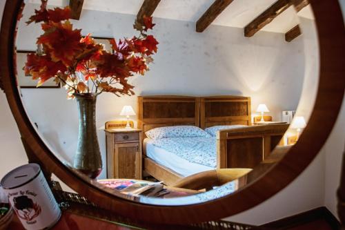 una camera da letto con un letto e un vaso con fiori in uno specchio di Villa Fausta B&B a Trieste