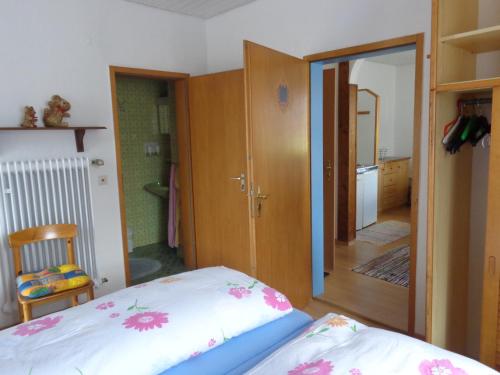 a bedroom with a bed and a door to a kitchen at Gästehaus Eschenhof in Reit im Winkl