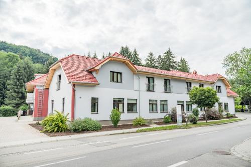 una casa blanca con techo rojo en una calle en Smart Liv'in Laabnerhof en Laaben