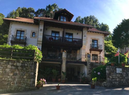 Cette grande maison est dotée d'un balcon sur un mur en pierre. dans l'établissement Posada Fuentedevilla, à Pechón