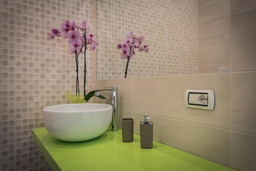 ein Badezimmer mit einem Waschbecken und Blumen auf der Theke in der Unterkunft L'Agrumeto in Procida
