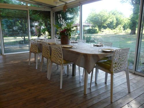 - une table à manger et des chaises sur une terrasse dans l'établissement l'Airial de Nahouns, à Sabres